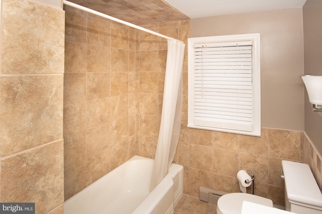 bathroom with toilet, shower / bath combo with shower curtain, and tile walls