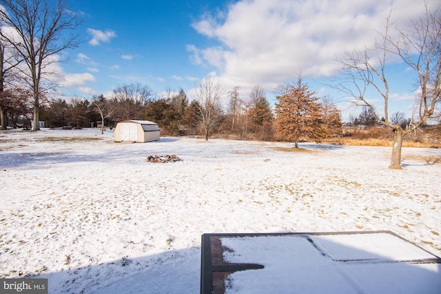 yard layered in snow with a storage shed