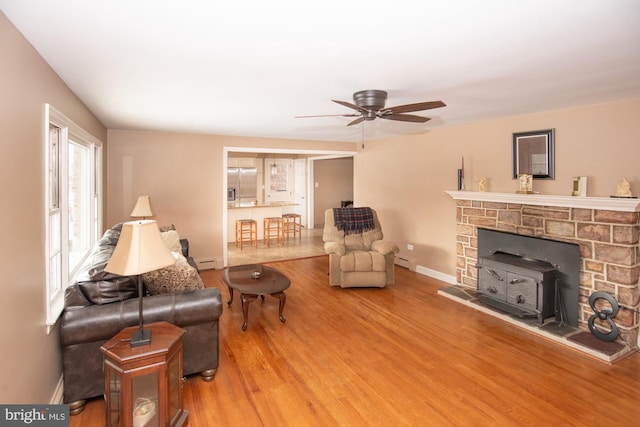 living room with wood-type flooring, ceiling fan, and a baseboard radiator