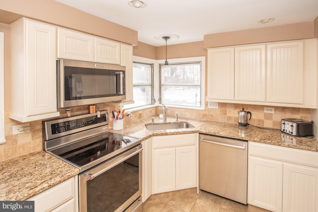 kitchen featuring tasteful backsplash, appliances with stainless steel finishes, sink, and pendant lighting