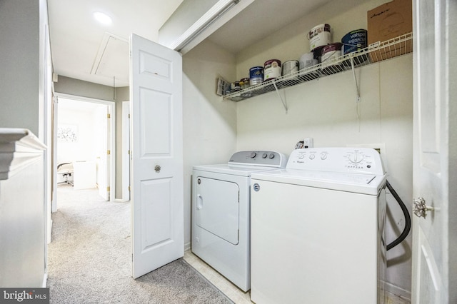 laundry room with washer and dryer and light carpet