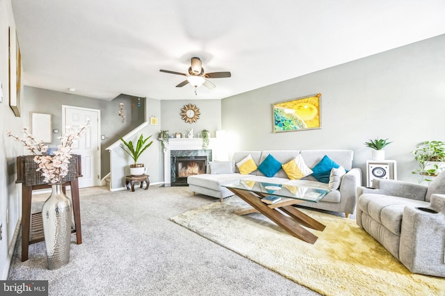 living room with a fireplace, carpet floors, and ceiling fan