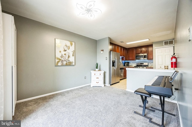 kitchen featuring appliances with stainless steel finishes, light carpet, and kitchen peninsula