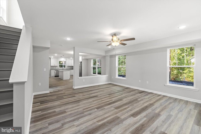 unfurnished living room featuring ceiling fan and wood-type flooring