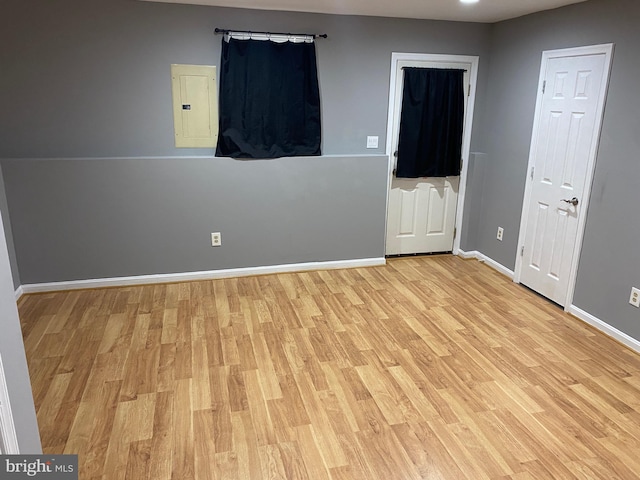 unfurnished bedroom featuring electric panel and light hardwood / wood-style flooring