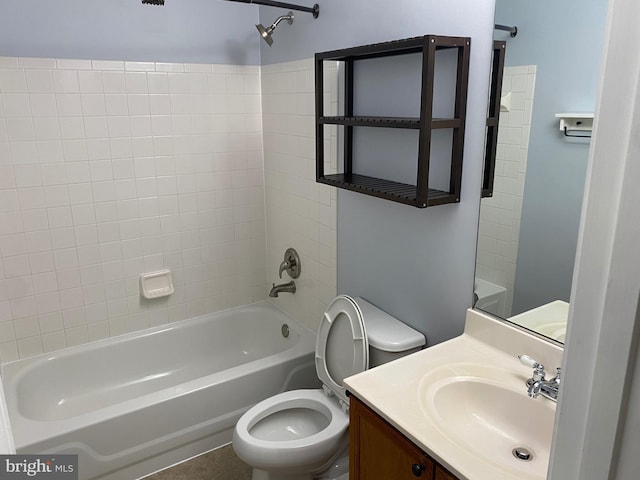 full bathroom featuring tiled shower / bath, vanity, and toilet