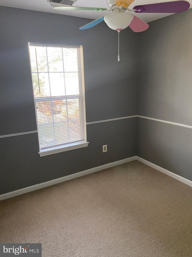 unfurnished room with ceiling fan and carpet