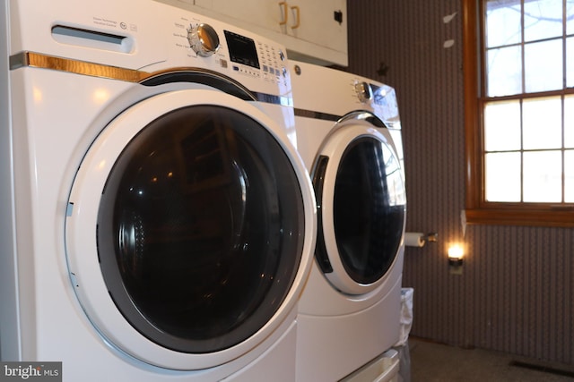 laundry area with cabinets, separate washer and dryer, and plenty of natural light