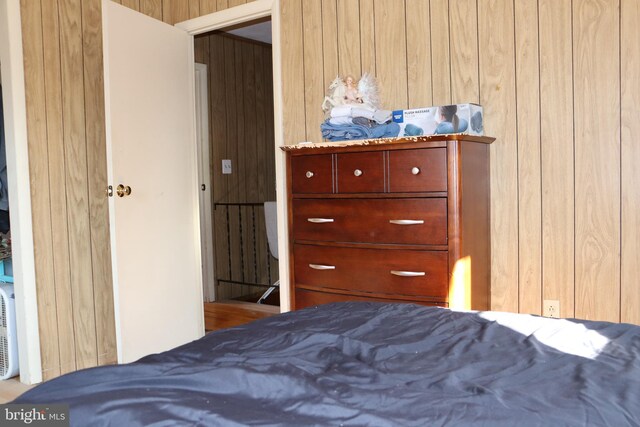 bedroom featuring wood walls