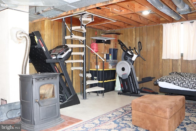 workout area featuring a wood stove and wood walls