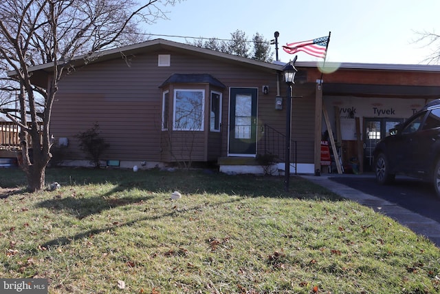 view of front of property with a carport and a front lawn