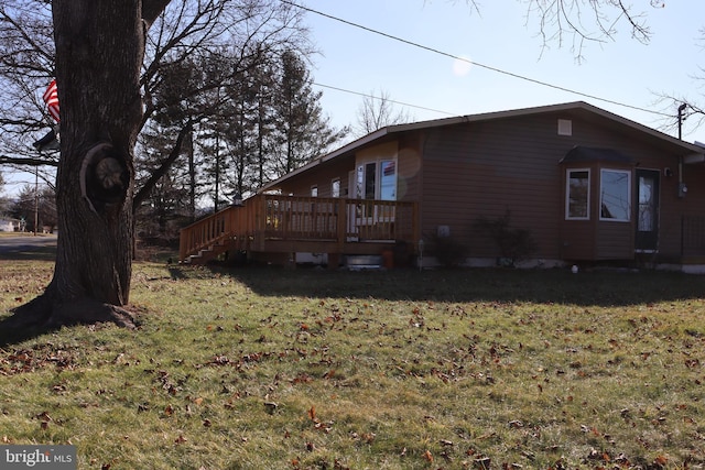 view of side of property featuring a yard and a deck