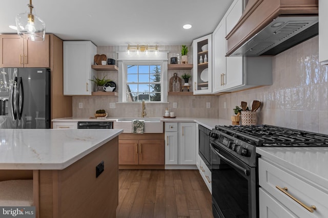 kitchen featuring white cabinetry, light stone countertops, custom range hood, and black appliances