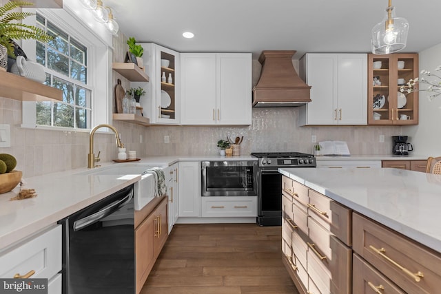 kitchen with stainless steel gas stove, built in microwave, white cabinetry, black dishwasher, and custom exhaust hood