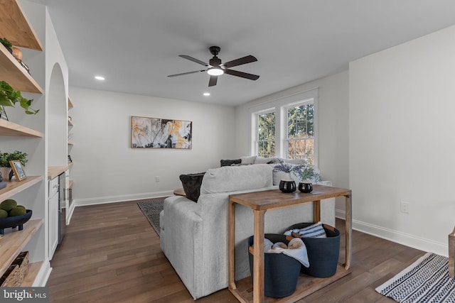 living room with dark wood-type flooring and ceiling fan