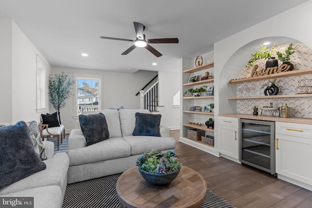 living room featuring wine cooler, indoor bar, dark hardwood / wood-style flooring, built in features, and ceiling fan