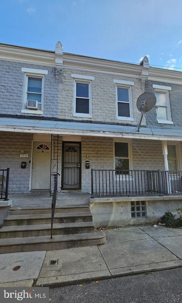 townhome / multi-family property with cooling unit and covered porch