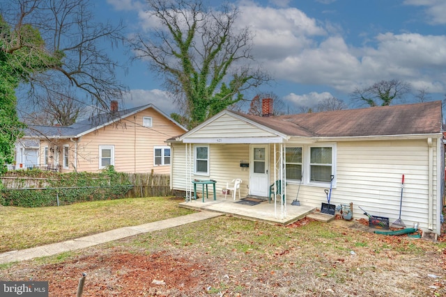 rear view of house with a patio and a yard