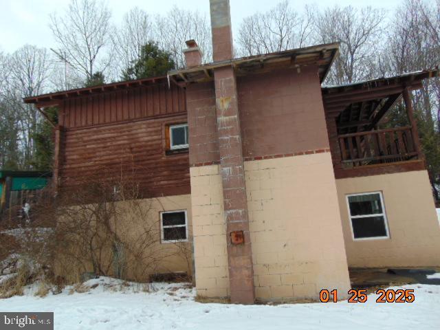 view of snow covered exterior with a balcony