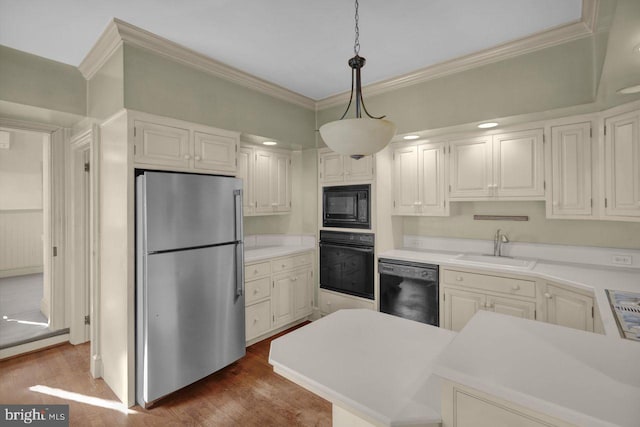 kitchen with pendant lighting, sink, black appliances, and white cabinets