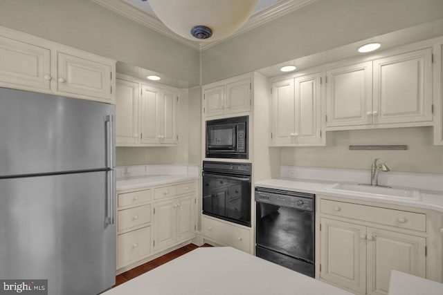 kitchen featuring crown molding, white cabinets, sink, and black appliances