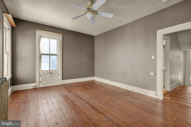 empty room with hardwood / wood-style flooring and ceiling fan