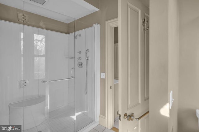 bathroom with a shower with door and tile patterned flooring