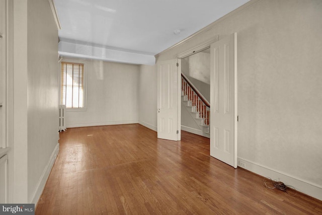 spare room featuring radiator heating unit and wood-type flooring