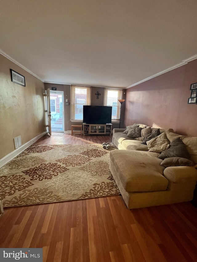 unfurnished living room featuring hardwood / wood-style flooring and ornamental molding