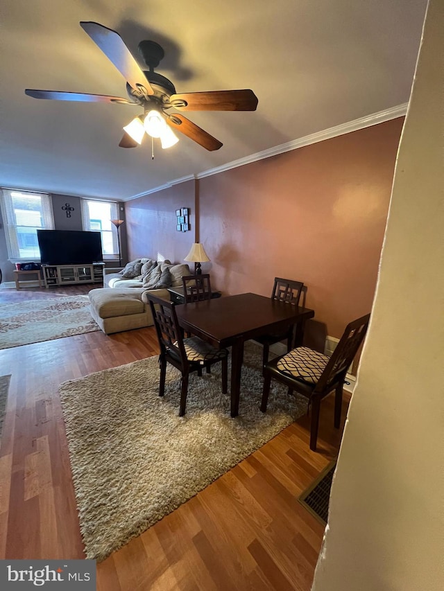 dining room featuring hardwood / wood-style floors, ornamental molding, and ceiling fan