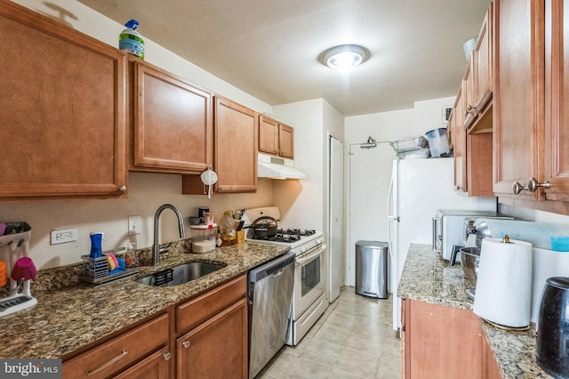 kitchen with light tile patterned floors, sink, dishwasher, stone countertops, and white gas range