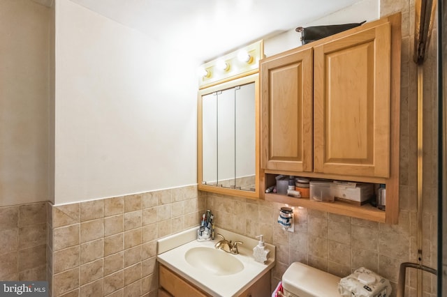 bathroom with tile walls, vanity, and toilet