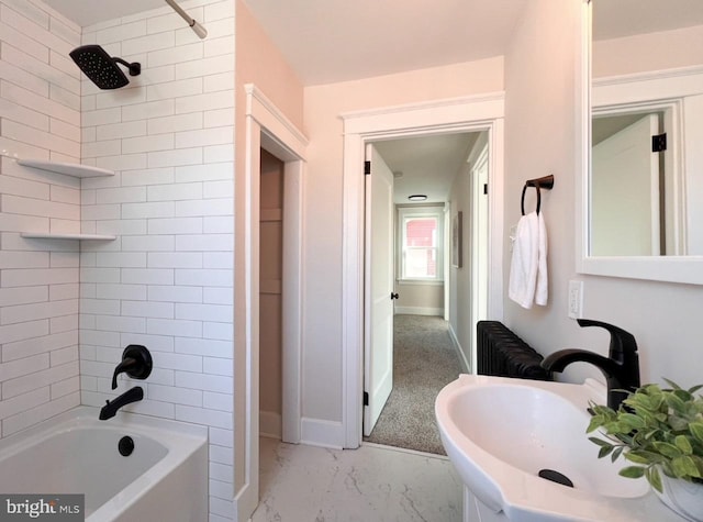 bathroom with sink, radiator heating unit, and tiled shower / bath