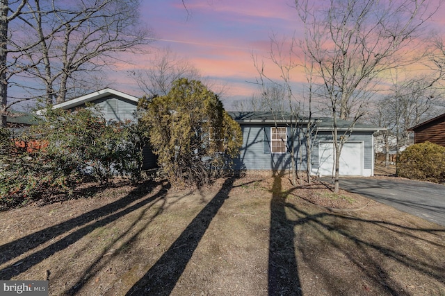 ranch-style house with a garage and a lawn