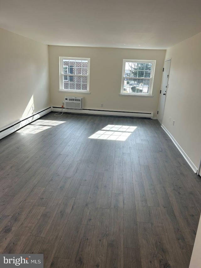 empty room with dark wood-type flooring and an AC wall unit