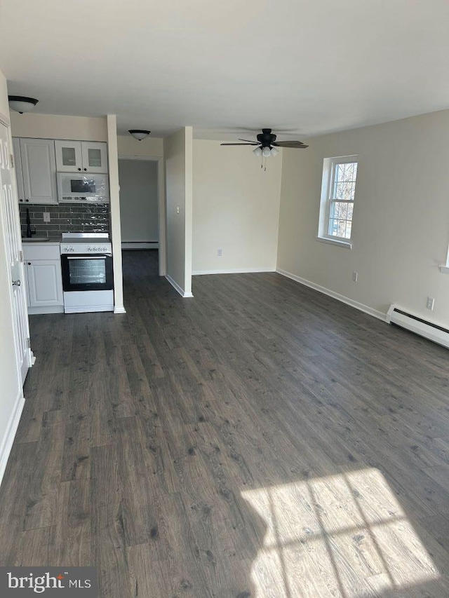 unfurnished living room with dark wood-type flooring, a baseboard radiator, and ceiling fan