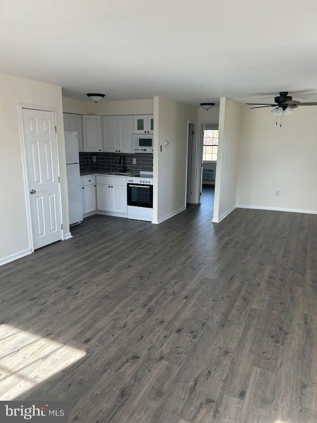 kitchen featuring dark hardwood / wood-style floors, tasteful backsplash, sink, white cabinets, and white appliances