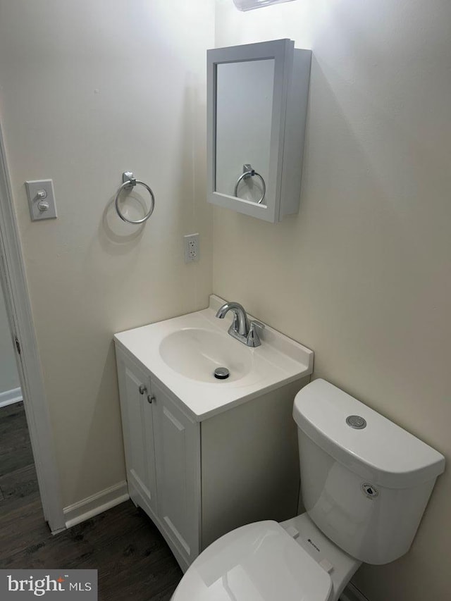 bathroom featuring vanity, toilet, and hardwood / wood-style floors