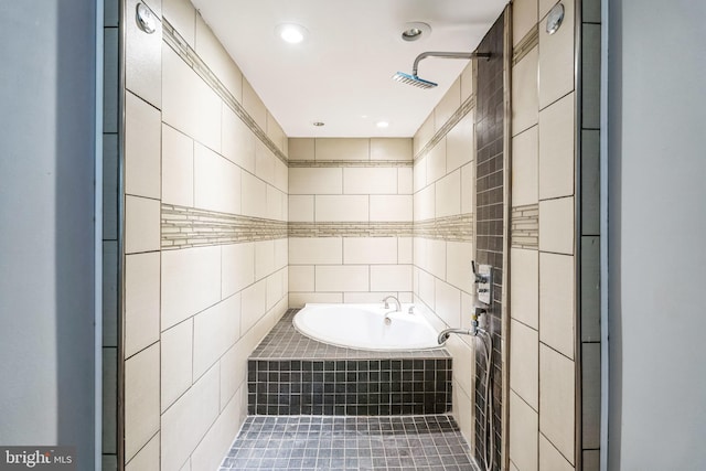 bathroom with tile walls, tile patterned floors, and tiled bath