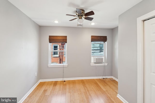 empty room with wood-type flooring, a wealth of natural light, ceiling fan, and cooling unit