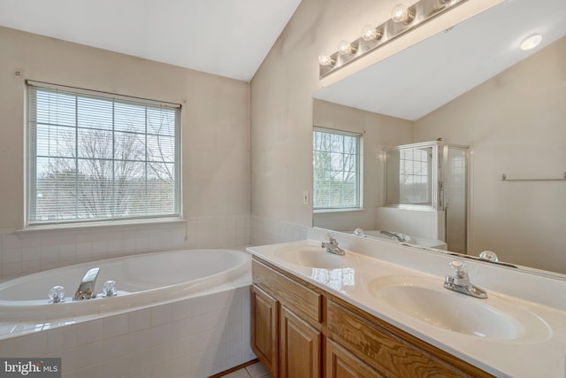 full bathroom featuring lofted ceiling, a bath, and a sink