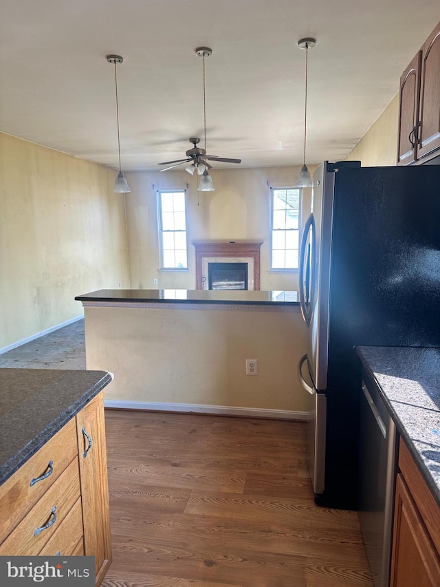 kitchen featuring dark countertops, ceiling fan, dark wood finished floors, appliances with stainless steel finishes, and plenty of natural light