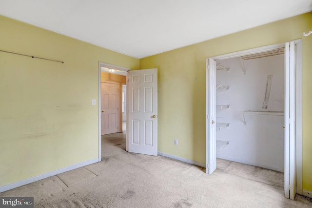 unfurnished bedroom with a closet, baseboards, and carpet