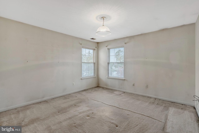 unfurnished room with visible vents, baseboards, and carpet