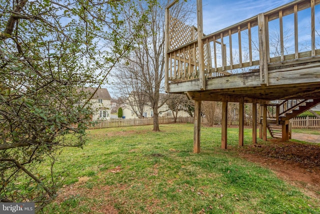 view of yard with a deck, stairway, and fence