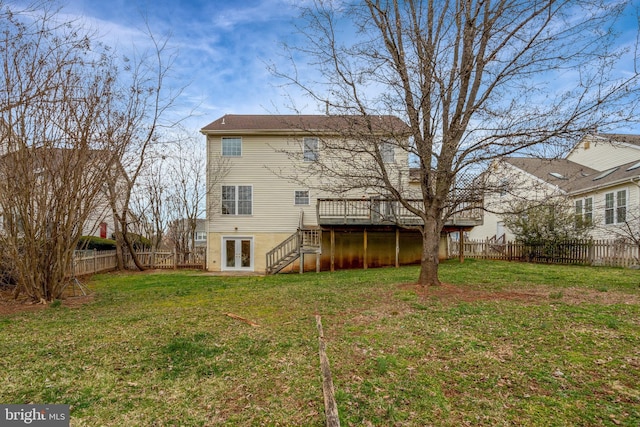 rear view of house with stairway, a wooden deck, a fenced backyard, french doors, and a lawn