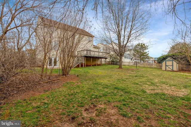 view of yard with an outbuilding, a deck, fence, a shed, and stairs