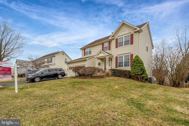 traditional home featuring aphalt driveway and a front lawn