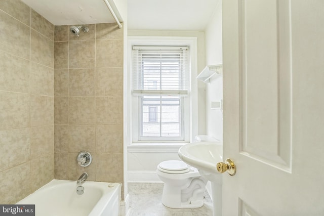 bathroom with tiled shower / bath combo and toilet