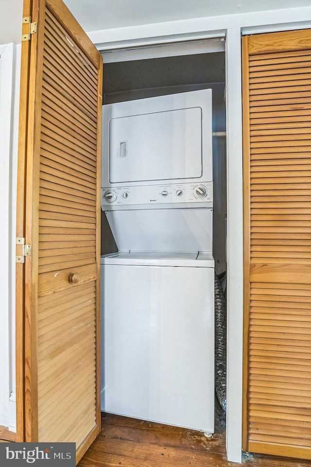 washroom featuring stacked washer and dryer and dark hardwood / wood-style floors